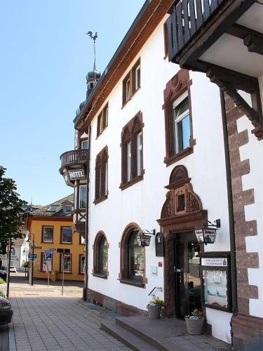 a white building with a balcony on a street at Hotel Neustädter Hof in Titisee-Neustadt