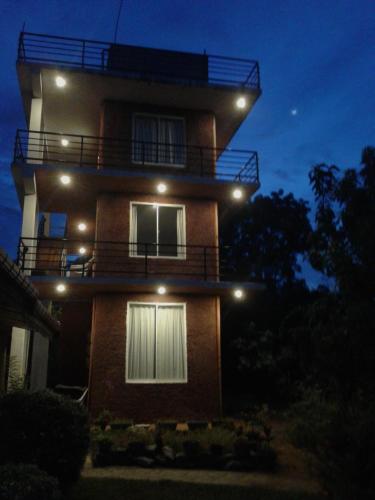 a building with lights on top of it at night at Sigiriya Water Guest & View Point Restaurant in Sigiriya