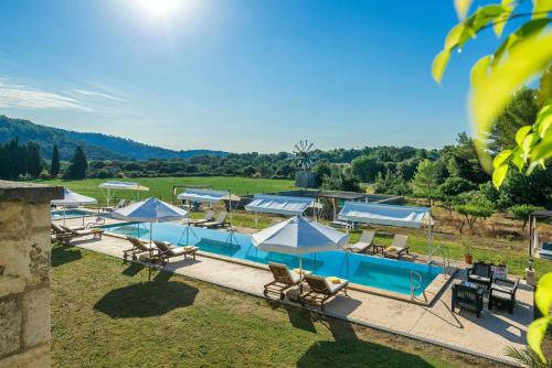 a pool with blue and white umbrellas and chairs at Monnaber Nou Finca Hotel & Spa in Campanet