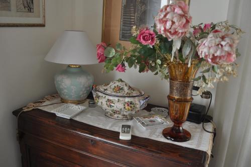 a table with a lamp and a vase with flowers on it at Villa L'Aurora in Pescara