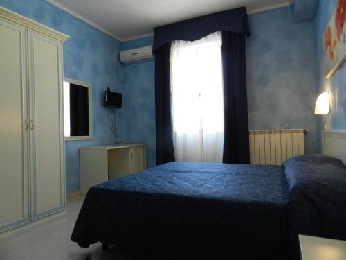 a blue bedroom with a bed and a window at Hotel Air Palace Lingotto in Turin