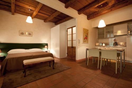 a bedroom with a bed and a table and a kitchen at Residenza i Platani in Santarcangelo di Romagna