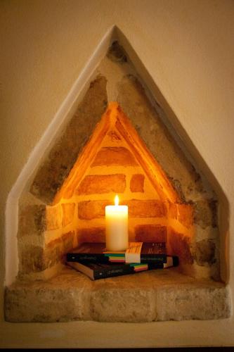 a candle and books sitting on a stone wall with a candle gmaxwell gmaxwell gmaxwell at Residenza i Platani in Santarcangelo di Romagna