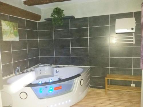 a bathroom with a white tub in a room at L échappée belle in Laviolle