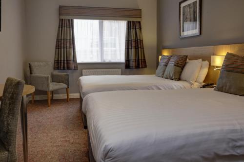 a hotel room with two beds and a window at Linton Lodge a BW Signature Collection Hotel in Oxford