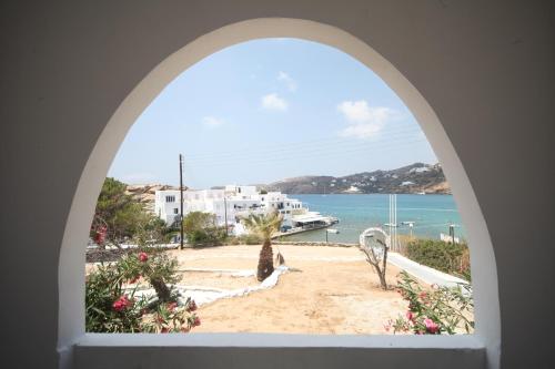 an arched window with a view of the ocean at Ios Plage in Mylopotas