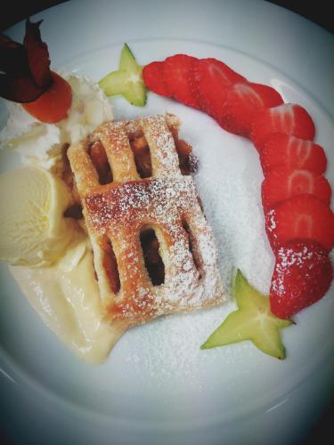 a plate of food with a waffle and fruit at Hotel & Restaurant Zur Weintraube in Jena