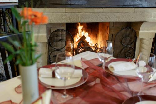 a table with wine glasses in front of a fireplace at Hotel Helen in Bacău