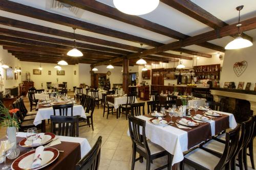 a restaurant with tables and chairs in a room at Hotel Helen in Bacău