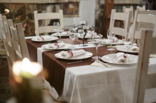 a table with white plates and wine glasses on it at Hotel Helen in Bacău