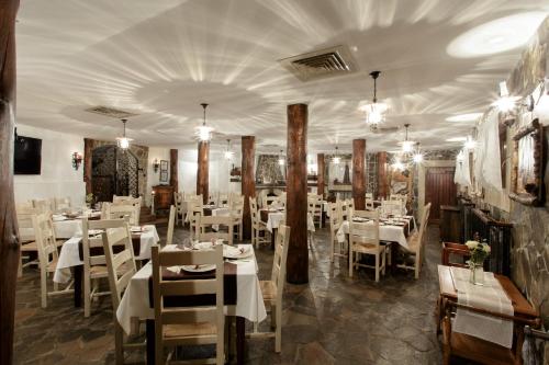 a dining room with white tables and white chairs at Hotel Helen in Bacău
