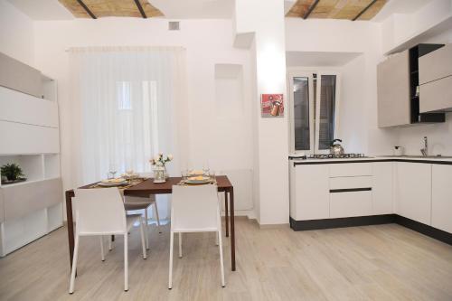 eine Küche mit einem Holztisch und weißen Schränken in der Unterkunft LATERANO 250 - COLOSSEO in Rom