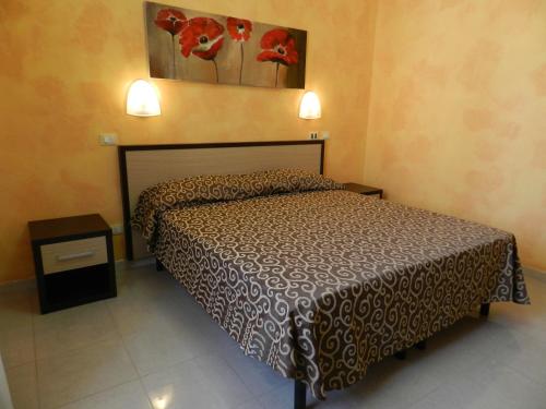 a bedroom with a bed and two lights on the wall at Hotel Air Palace Lingotto in Turin