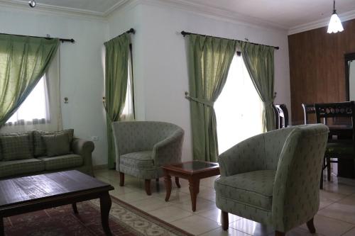 a living room with two chairs and a coffee table at Dynasty Suite in Aley