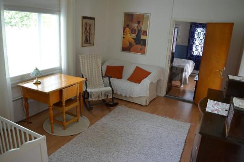 a living room with a table and a bed and a desk at Luntinmäen omakotitalo in Keskikylä