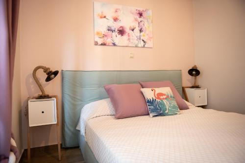 a bedroom with a bed with pink and pink pillows at Traditional Thiseio Home in Athens