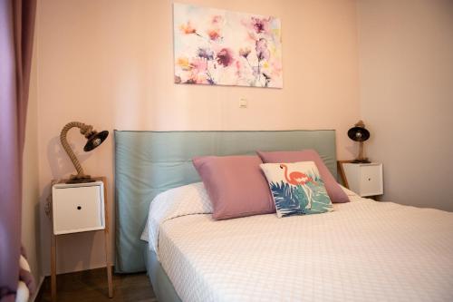 1 dormitorio con 1 cama con almohadas rosas y rosas en Traditional Thiseio Home, en Atenas