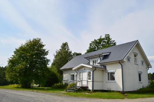 a white house with a gray roof on a street at Luntinmäen omakotitalo in Keskikylä