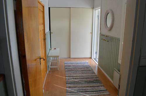 a hallway with a door and a rug on the floor at Luntinmäen omakotitalo in Keskikylä