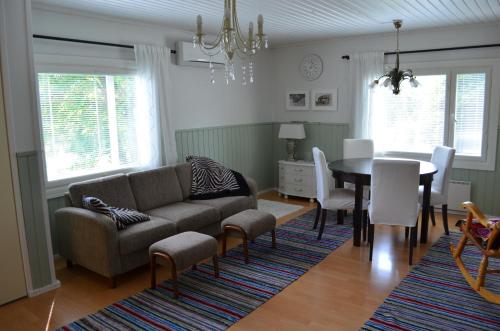 a living room with a couch and a table at Luntinmäen omakotitalo in Keskikylä