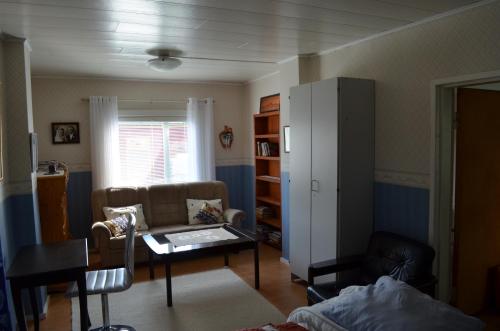 a living room with a couch and a table at Luntinmäen omakotitalo in Keskikylä