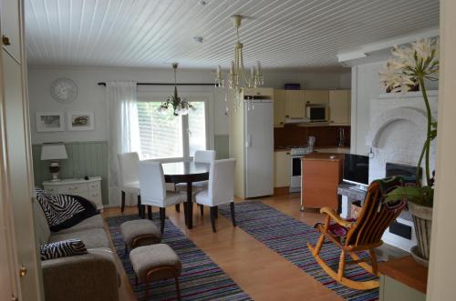 a living room and kitchen with a table and chairs at Luntinmäen omakotitalo in Keskikylä