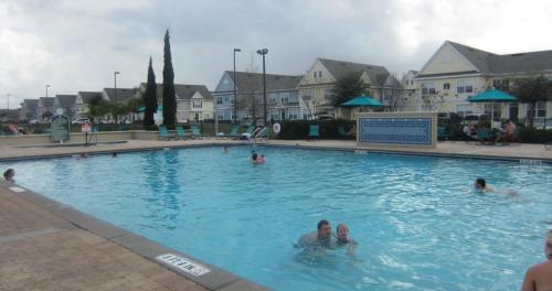 a group of people swimming in a swimming pool at Orlando House in Kissimmee