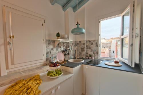 a kitchen with a counter with a bowl of fruit on it at Le tre muse in Siracusa