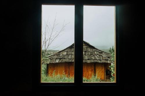 an open window looking out at a wooden building at Mu Cang Chai Eco Lodge in Nam San