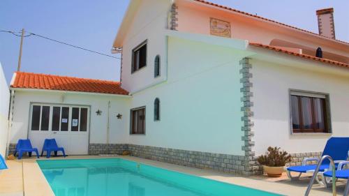 a villa with a swimming pool in front of a house at Moradia O Pinhal, S. Lourenço - Ericeira in Casais de São Lourenço