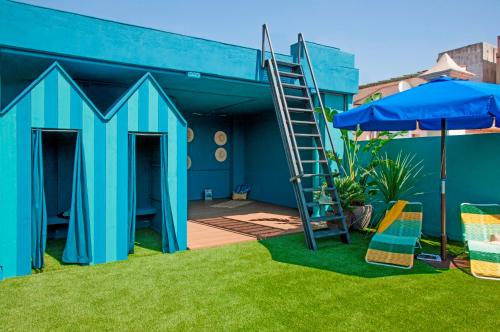 a blue play house with a ladder and an umbrella at Chic & Basic Velvet in Barcelona