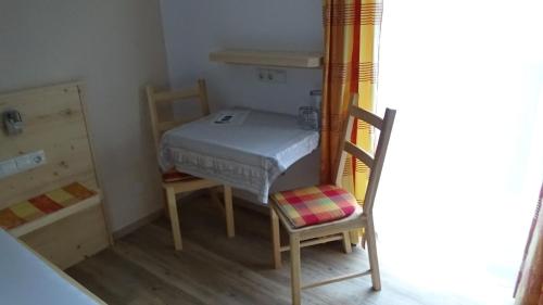 a small room with a bed and two chairs at Haus Bergheim in Sankt Leonhard im Pitztal
