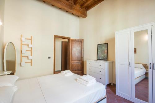 een witte slaapkamer met een bed en een spiegel bij Ognissanti apartment in Florence