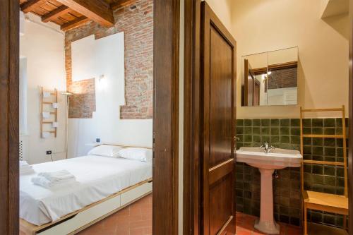 a bathroom with a bed and a sink in a room at Ognissanti apartment in Florence