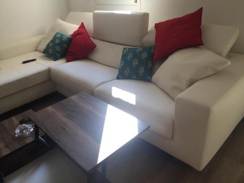 a white couch with red and blue pillows on it at Modern Flat Lecce ++ in Lecce