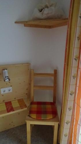 a bedroom with two bunk beds and a chair at Haus Bergheim in Sankt Leonhard im Pitztal