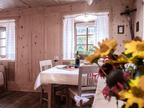 a dining room with a table and two windows at Landhaus Strickenmacher in Sillian
