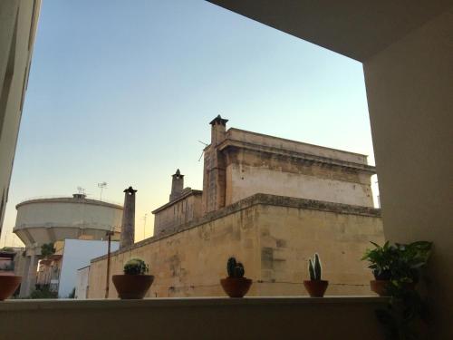 a window with potted plants on a window sill at Modern Flat Lecce ++ in Lecce