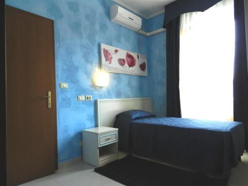a bedroom with blue walls and a bed and a window at Hotel Air Palace Lingotto in Turin