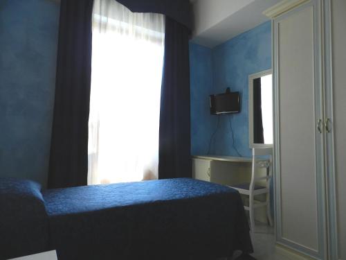 a bedroom with a bed and a window and a desk at Hotel Air Palace Lingotto in Turin