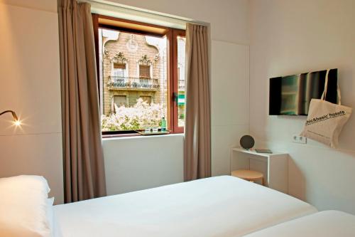 a bedroom with a bed and a window at Chic & Basic Velvet in Barcelona