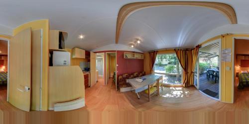 Cette chambre comprend une cuisine et une salle à manger. dans l'établissement Camping Les Grillons, à Embrun