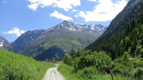 a dirt road with mountains in the background at Haus Bergheim in Sankt Leonhard im Pitztal