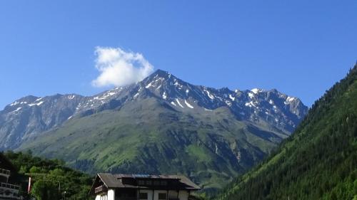 a snow covered mountain with a house in front of it at Haus Bergheim in Sankt Leonhard im Pitztal