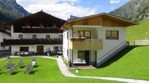 a house on a hill with a green lawn at Haus Bergheim in Sankt Leonhard im Pitztal