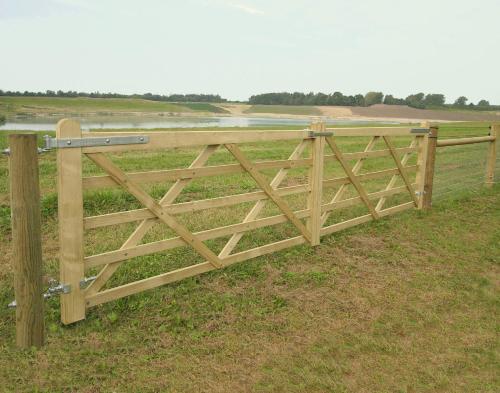 a wooden fence in the middle of a field at Country flat in Roskilde