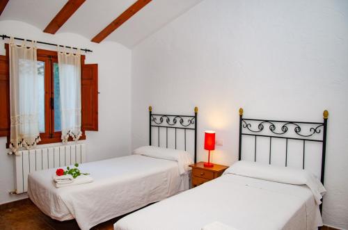 2 łóżka w pokoju z białymi ścianami w obiekcie Casas Rurales Mirador del Mundo w mieście Yeste