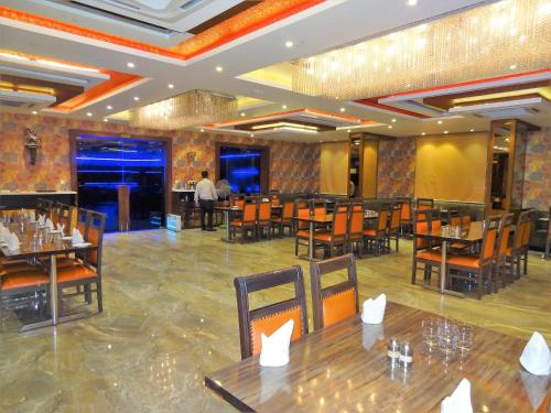 a restaurant with tables and chairs in a room at JM Vistaraa in Bareilly
