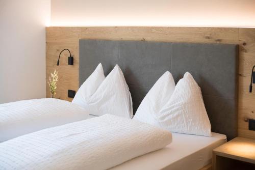 a bedroom with two beds with white pillows at Sinnergut in Nalles