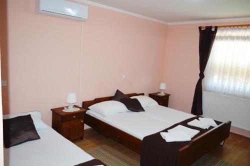 a bedroom with two beds and a window at Gostilna s prenocisci Danica in Slovenska Bistrica